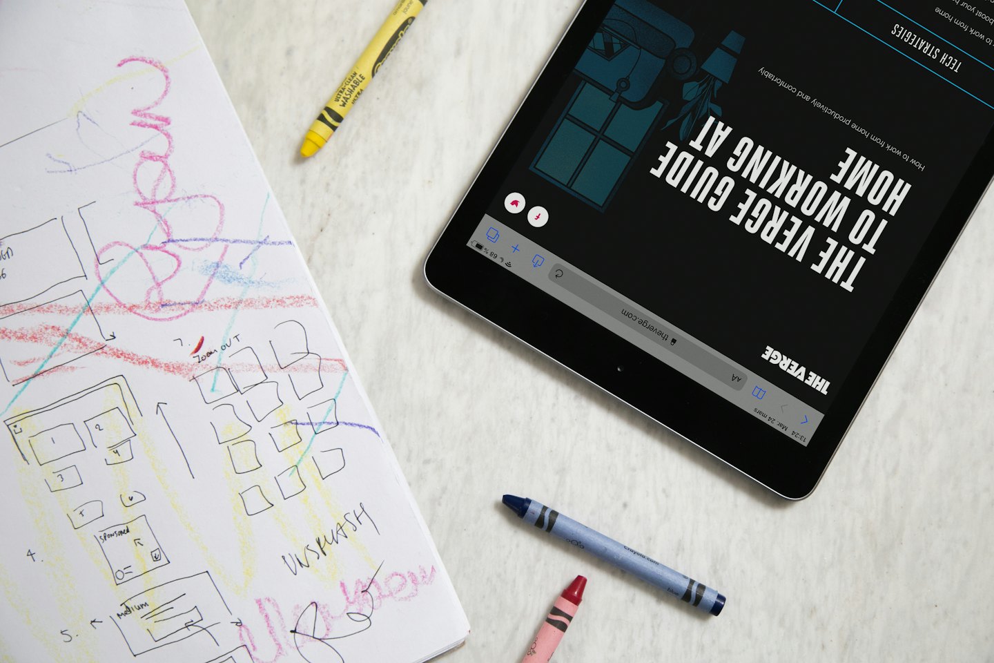 Ein Tablet und ein Design-Skizzenbuch liegen auf einem Schreibtisch.